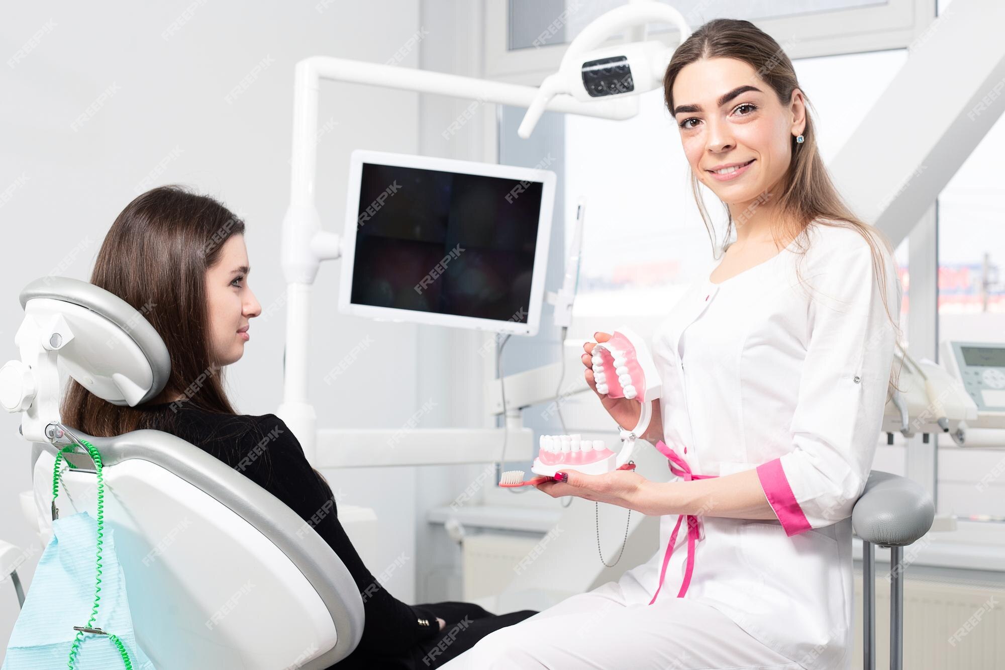 Premium Photo | Dentist showing a woman how to brush his teeth properly