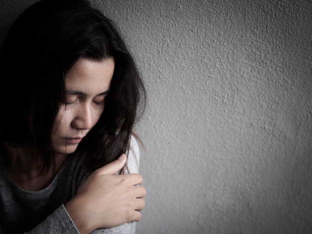 家の中の暗い部屋に一人で座ってうつ病の憂鬱な女性 孤独 悲しい 愛 プレミアム写真