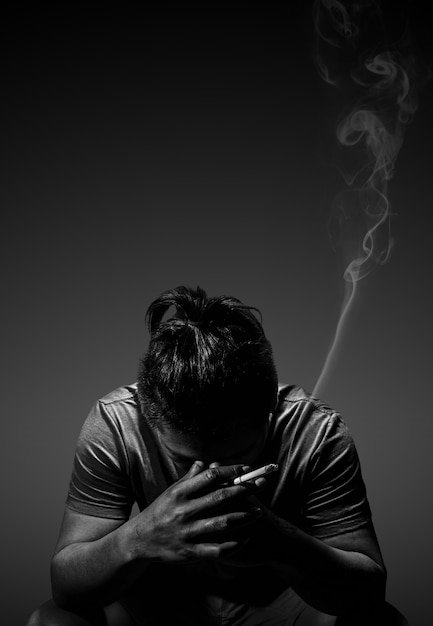 depressed-man-smoking-cigarette-sitting-chair-black_104033-84.jpg
