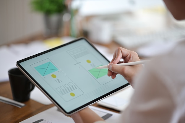 Designer using tablet planning wireframe a mobile website, ux ui app development Premium Photo