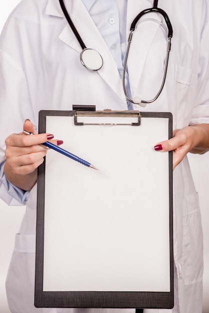 Detail of a doctor with stethoscope holding a clipboard | Free Photo