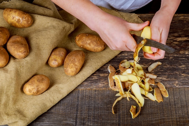 Premium Photo | Detail of woman hands peeling fresh yellow potato with ...