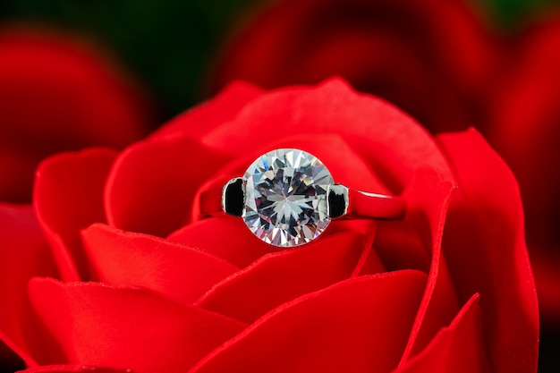 Premium Photo | Diamond wedding ring on red roses