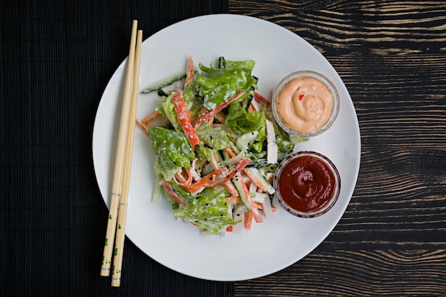 Dietary food, fresh vegetable salad with imitation of crab stick, seasoned with soy sauce and japanese sesame. Premium Photo