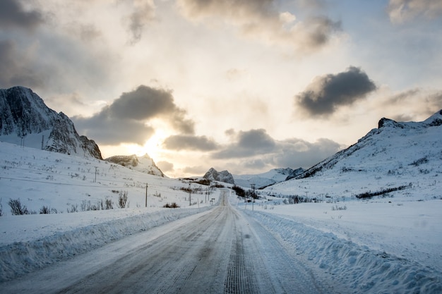 Premium Photo | Dirty snow road with sunlight on mountains