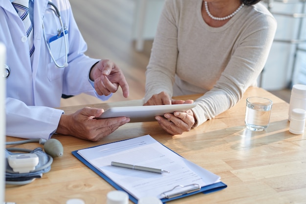 Discussing records with senior patient Free Photo