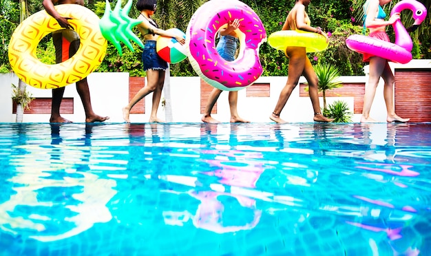 Premium Photo A Diverse Group Of Friends Enjoying Summer Time By The Pool With Inflatable Floats