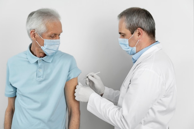 Premium Photo | Doctor administering vaccine shot to male patient