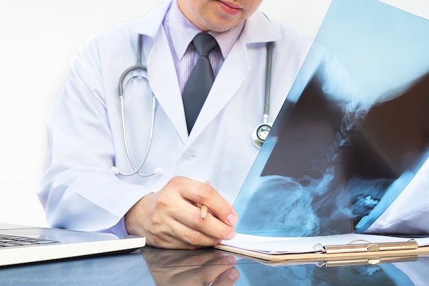 Doctor examine x-ray film over white background