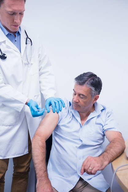 Premium Photo | Doctor giving injection to his patient