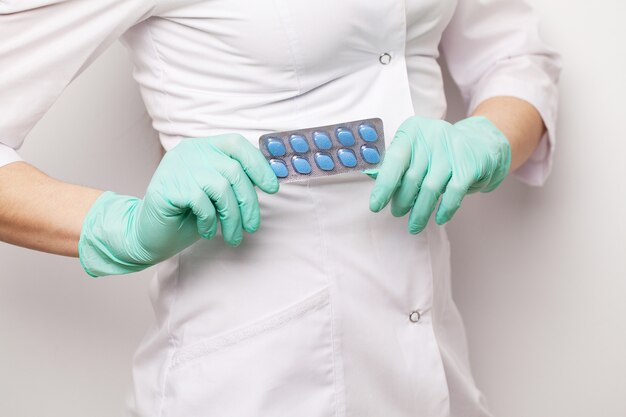 Premium Photo | Doctor in gloves holds pills for men's sexual health