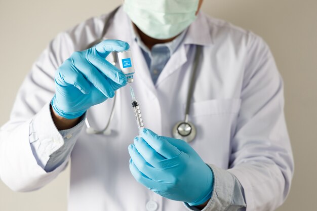 Premium Photo | Doctor holds syringe and bottle treatment vaccine