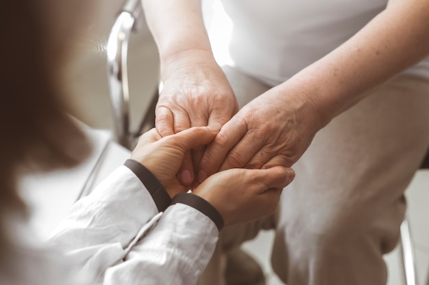 医者は年配の女性の手を握る プレミアム写真