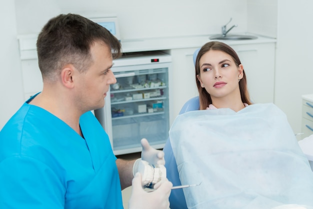 Premium Photo Doctor Orthodontist Explains To Her Patient What He Will Do