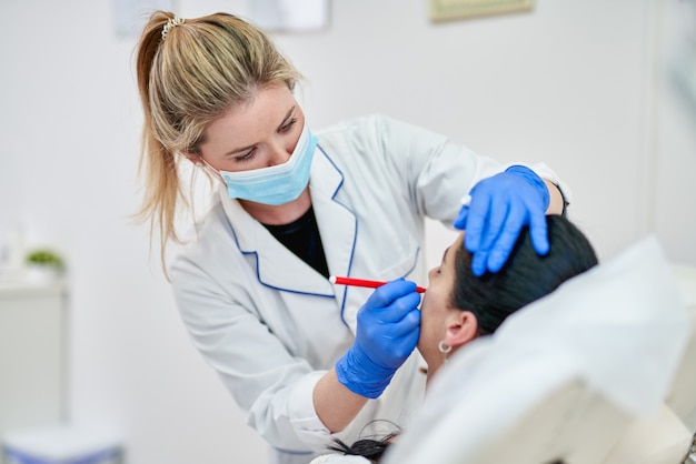 Premium Photo Doctor Preparing Female Patient For Cosmetic Surgery In