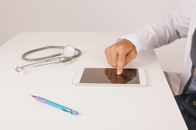 Doctor's hand touching tablet's screen Free Photo