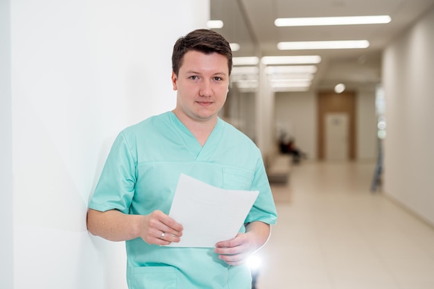 Premium Photo | Doctor in scrubs holding a document and posing in a ...