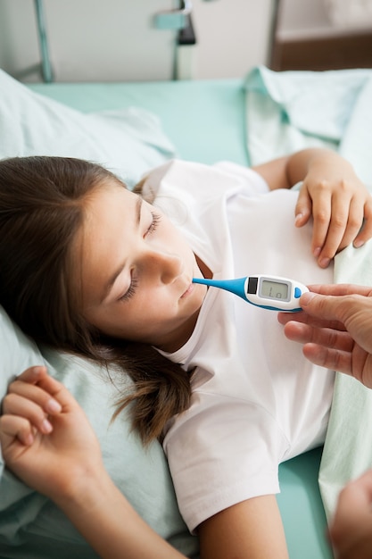 Premium Photo | Doctor taking body temperature of her patient in ...