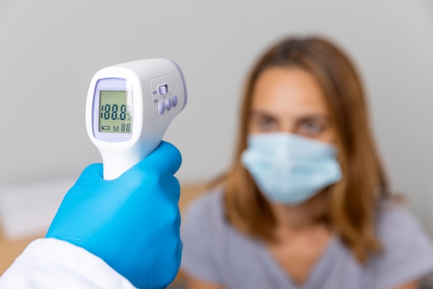 Premium Photo | Doctor with gloves checking patient's temperature with ...