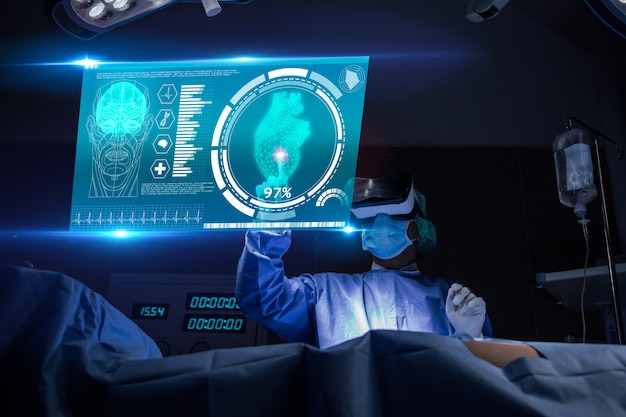 Doctor with virtual reality in operation room in hospital.surgeon analyzing patient heart testing result and anatomy on technological digital futuristic virtual interface Premium Photo