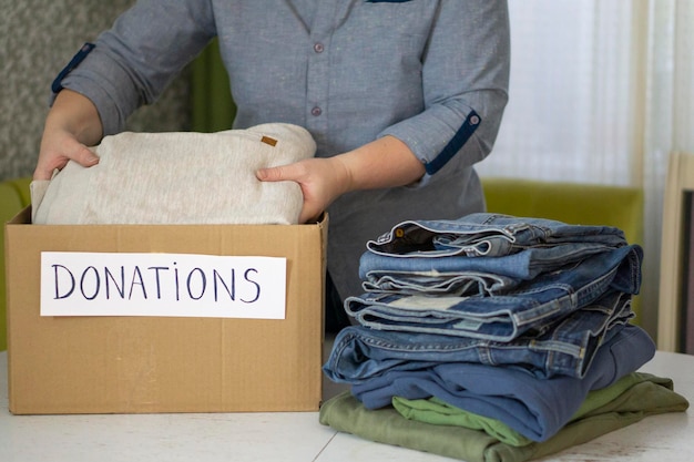 Premium Photo | The donation box for clothes is on the table. woman ...