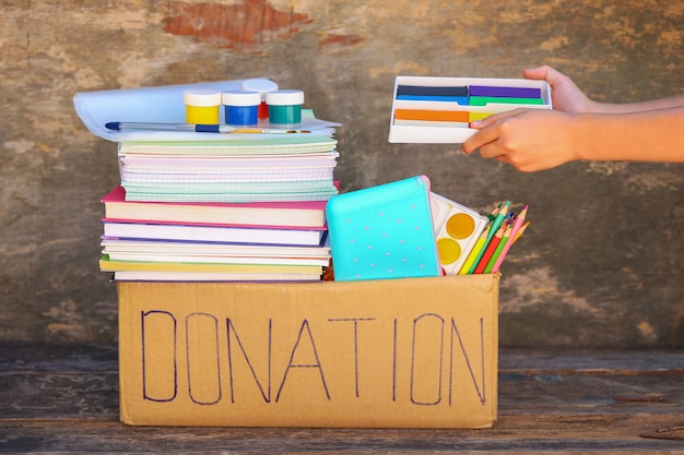 Premium Photo | Donation box with school supplies on old wooden table