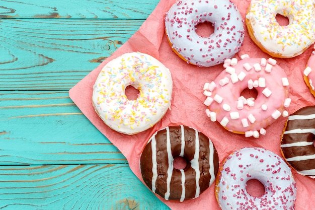 Premium Photo | Donuts on colorful wooden table