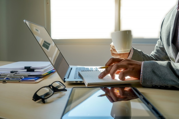 Double exposure of business man hand working on laptop computer on wooden desk with social media network diagram Premium Photo