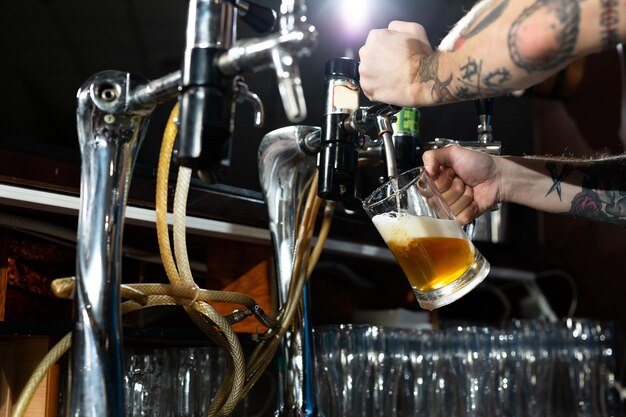 Premium Photo | Draft beer pour in a glass from the crane. waiter pours ...