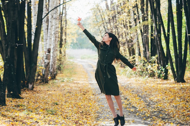 Dreamy Girl With Long Natural Black Hair Flies On Autumn Background With Trees And Yellow Leaves In Bokeh Premium Photo
