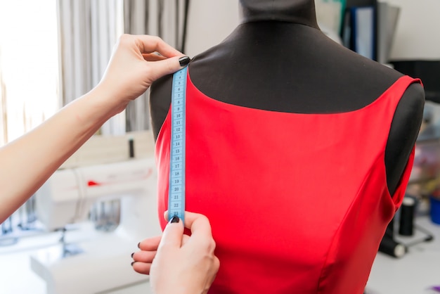 Premium Photo | Dressmaker designer working with mannequin in dress ...