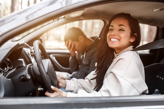 運転指導 若い女性は車を運転することを学びます 彼女のインストラクターやボーイフレンドは 彼女が車を運転する方法が好きではありません しかし 女の子は自分に満足し 男の言うことを聞きません プレミアム写真