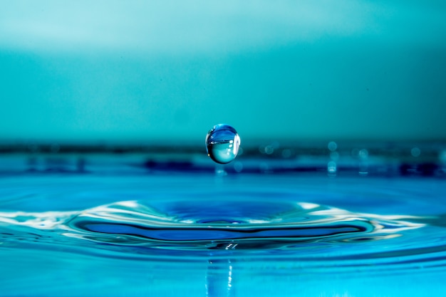 Premium Photo | Drop of water falling into a glass, hitting water ...