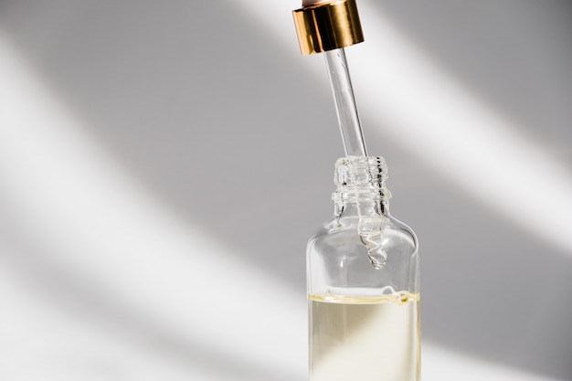 Download Dropper glass bottle mock-up. oily drop falls from cosmetic pipette on white background ...