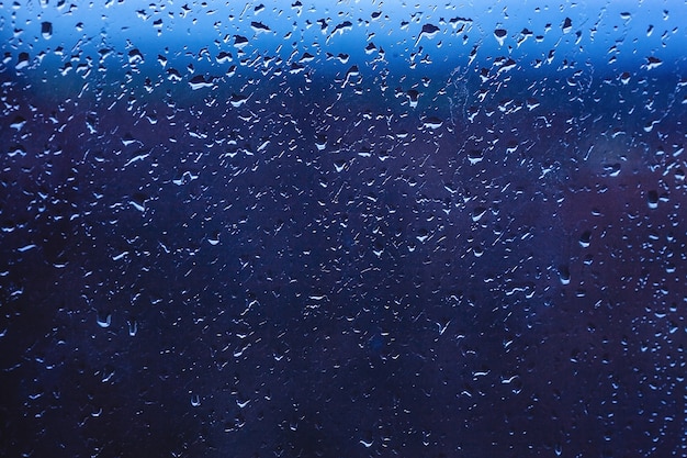 Drops of rain on the window. water on the glass. running drops. background conceptual. Premium Photo