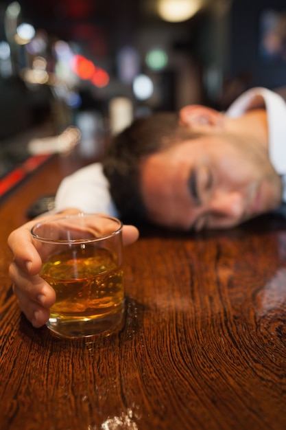 Premium Photo Drunk Businessman Holding Whiskey Lying On A Counter