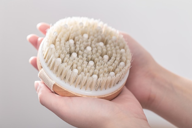 Dry massage brush made of natural materials in a female hands Free Photo