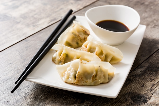 Premium Photo | Dumplings and soy sauce on wooden table