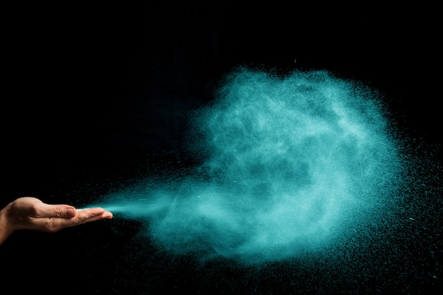 Premium Photo | Dust blows from hands on black background. color.