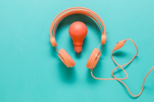 Earphones and lamp on colored surface Free Photo