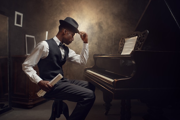 黒檀のグランドピアノ奏者 ジャズミュージシャン 演奏者がメロディーを演奏する前に楽器でポーズ プレミアム写真