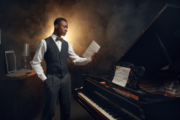 Premium Photo | Ebony pianist with music notebook in his hands on the ...