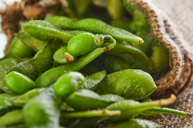 枝豆や大豆が袋から茶色の荒布にこぼれる プレミアム写真