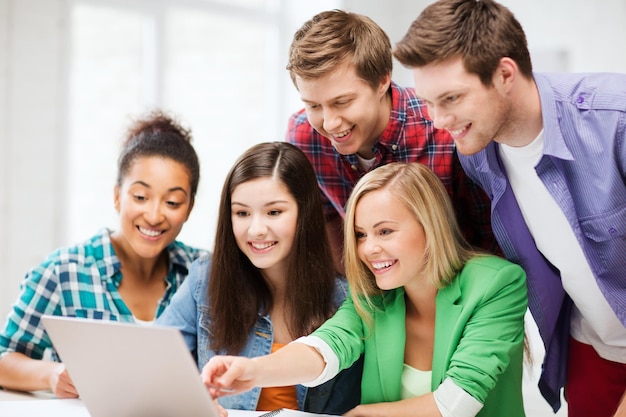 Premium Photo | Education concept - smiling students looking at laptop ...