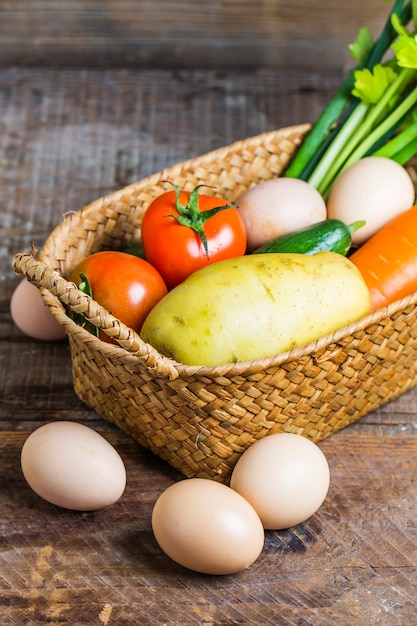 Eggs next to a basket with vegetables  Photo | Free Download