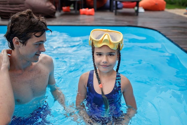 Premium Photo Elder Brother Training Little Sibling To Swim In Swimming Pool Outdoor At Summer