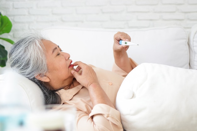 Premium Photo Elderly Asian Woman Lying Sick On The Sofa In The House Take Medication For