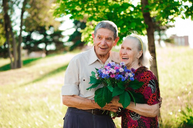 Premium Photo An Elderly Man Of 80 Years Old Gives Flowers To His Wife