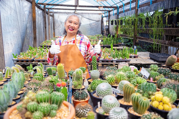 Elderly woman happy with a cactus farm | Free Photo