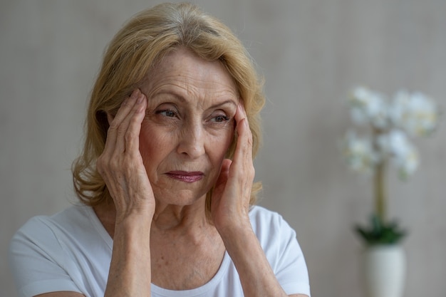 Premium Photo | An Elderly Woman Has Headaches She Touches Her Head ...